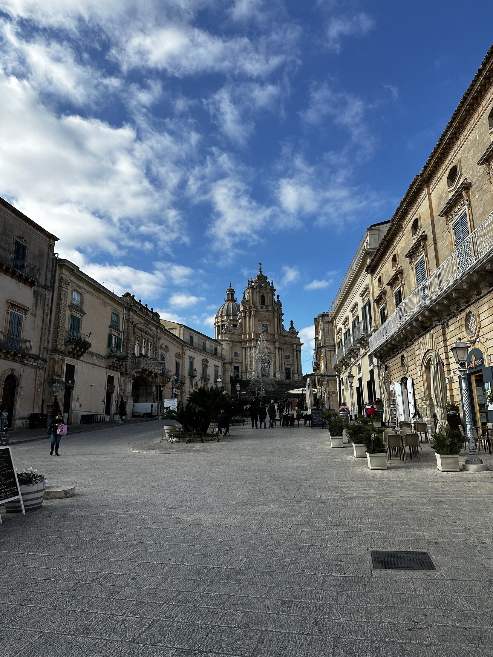 A historic Sicilian piazza beneath a deep blue sky