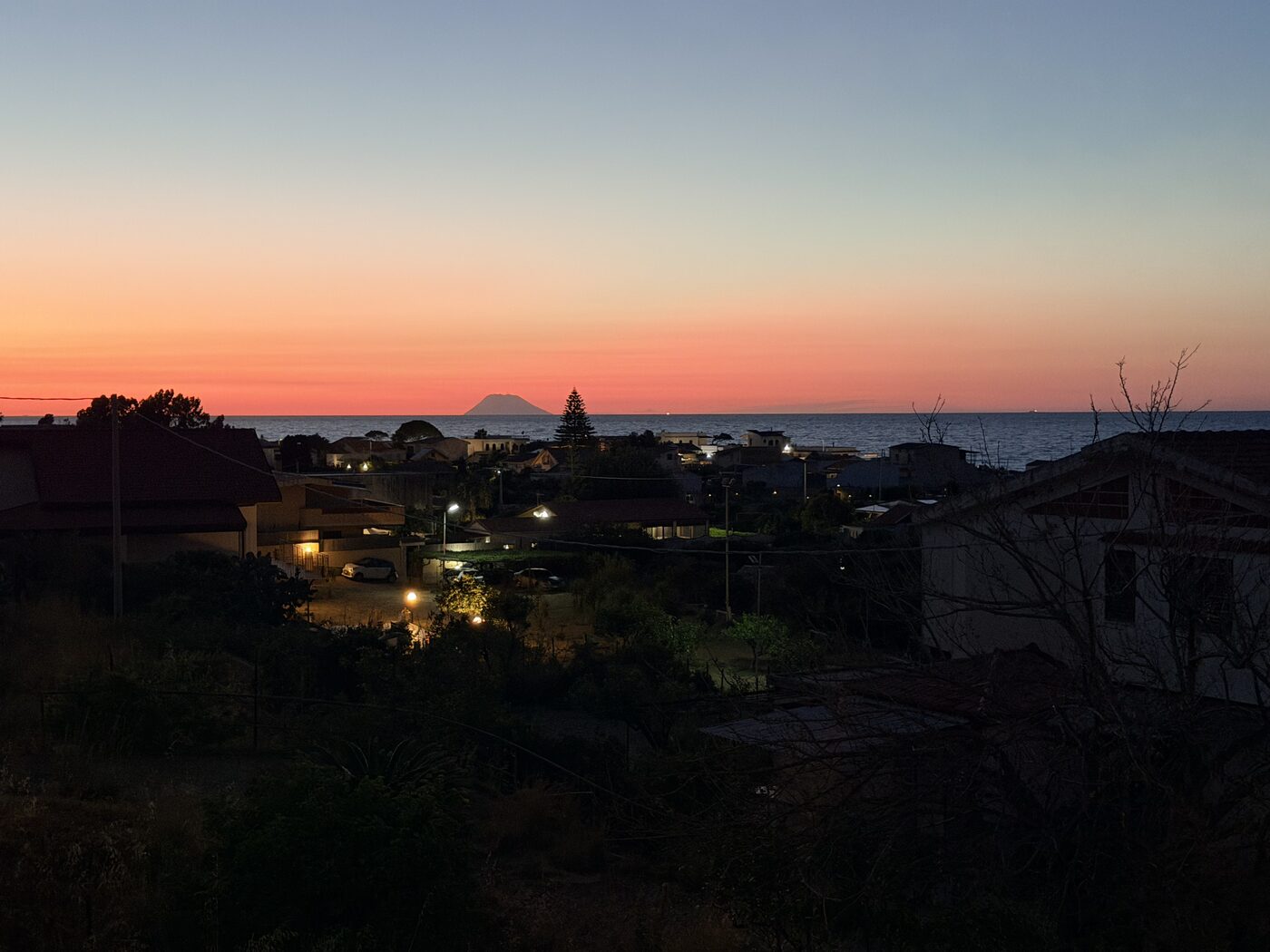 Distant islands beneath an orange dusk sky