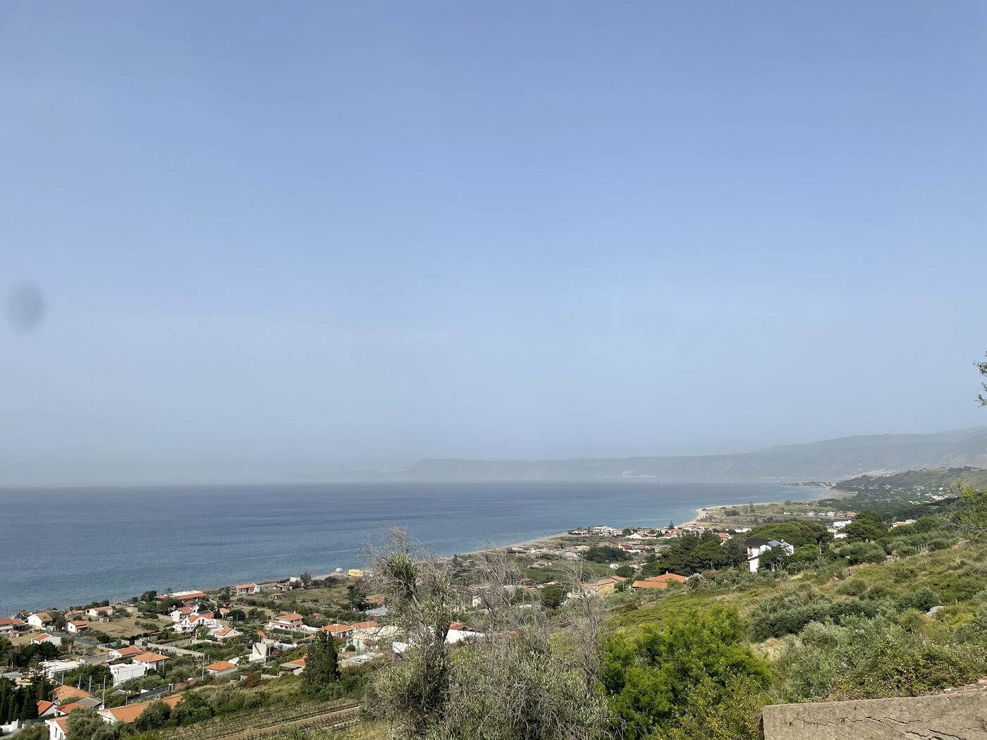 Coastal homes and the blue sea from a hillside